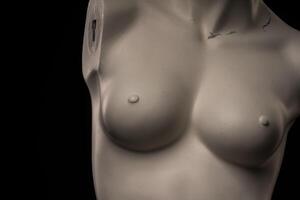 female mannequin torso isolated against dark studio background. photo