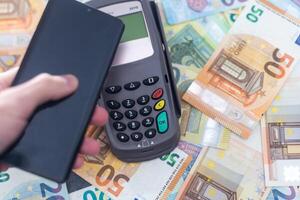 Banking terminal on euro banknotes background close up photo