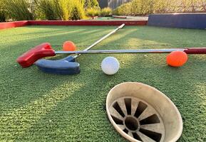 colorful golf putters with golf balls on synthetic grass photo