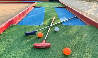 colorful golf putters with golf balls on synthetic grass photo