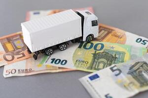 White toy truck lie on dollars, space for text. photo