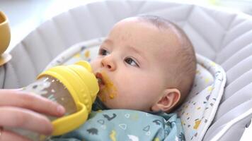 Baby Trinken Wasser von das Flasche mit ein Stroh während Fütterung video