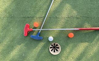 Golf ball and golf club on green in the evening golf course with sunshine photo