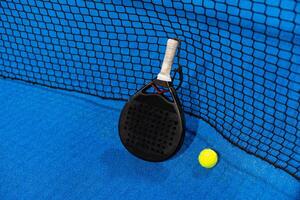 paddle tennis racket and balls on the blue paddle court photo