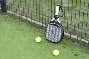 paddle tennis racket and balls on court photo