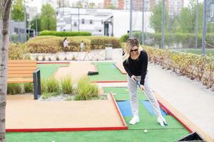 Playing Adventure Golf, downhill shot, ball, club and hole. photo