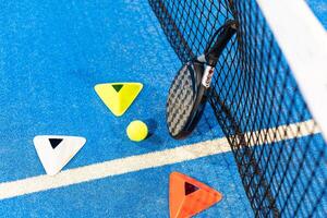 paddle tennis racket and balls on court, photo