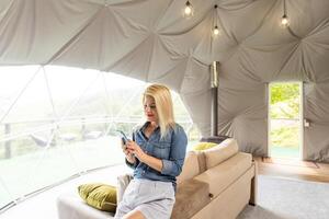 woman with smartphone in dome tent photo