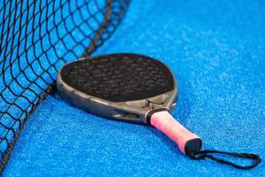 paddle tennis racket and balls on the blue paddle court photo