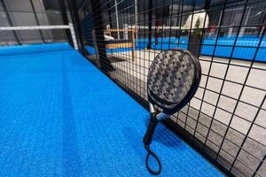 paddle tennis racket and balls on the blue paddle court photo