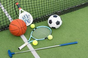 A group of sports equipment on background including tennis, basketball, and soccer on a background with copy space photo