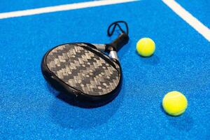 paddle tennis racket and balls on court, photo