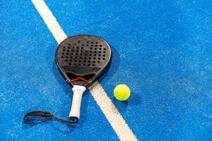 paddle tennis racket and balls on the blue paddle court photo