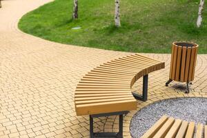 Wooden brown bench in the park, close-up. Wood texture. Empty bench in the summer park. photo