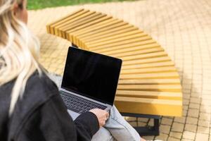 Businesswoman working with laptop in outdoor cafe. Corporate blog photo