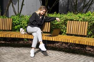 Businesswoman working with laptop in outdoor cafe. Corporate blog photo