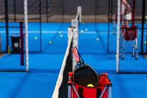 balls near the net of a blue padel tennis court photo