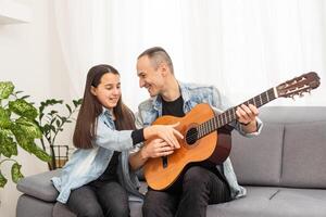 Happy family Father and daughter playing guitar. Father's day. photo