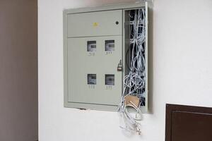 Electric cabinet with Internet and television cables in an apartment building. Niche for wires and cables inside the wall photo