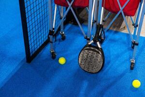 balls near the net of a blue padel tennis court photo