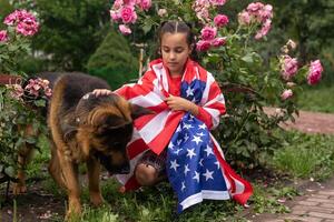 Pretty young pre-teen girl with an American cowboy hat in corn field and the holding American flag. photo