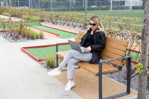 A businesswoman using a laptop on a golf course photo