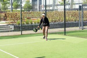 little girl playing padel and hitting the ball with his racket outdoors sports concepts photo
