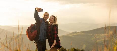 Happy traveler young couple resting in the mountains at sunset in spring or summer season. photo