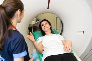 CT scan technologist overlooking patient in Computed Tomography scanner during preparation for procedure. Woman patient going into CT scanner. photo