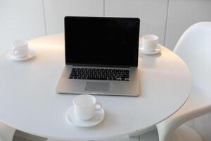 laptop on table with cups photo