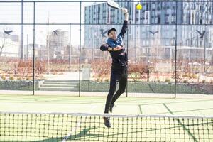 Paddle tennis player serving training with her couple in court photo