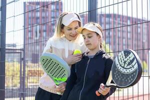 madre y hija jugando padel al aire libre foto