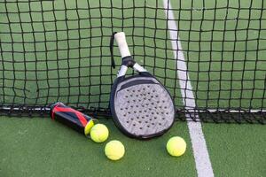 Paddle tennis racket, ball and net on the grass photo