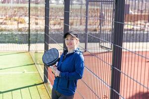 Determined sporty young woman playing padel in court photo