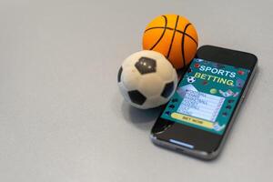 Sports betting website in a mobile phone screen, ball, money photo