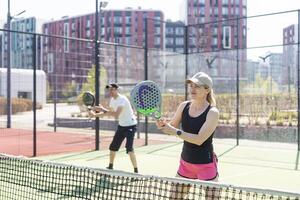 Ukraine Kyiv, April 02 2024. Padel training coach in a session, mentoring a female student, fostering skill development and a positive learning environment photo