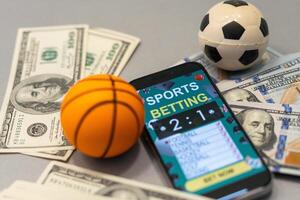 Sports betting website in a mobile phone screen, ball, money photo