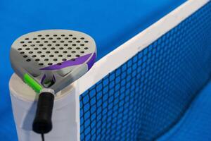 Black Paddle. Racket, balls an net in real court without logos. photo