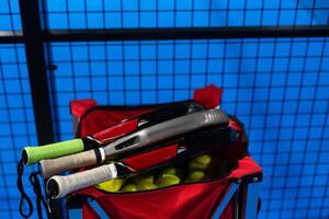 Black Paddle. Racket, balls an net in real court without logos. photo