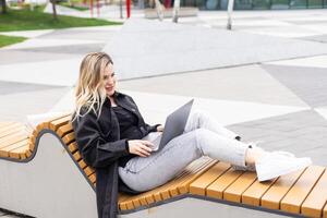 Businesswoman working with laptop in outdoor cafe. Corporate blog photo