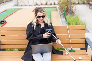 un mujer de negocios utilizando un ordenador portátil en un golf curso foto