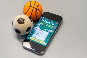 Sports betting website in a mobile phone screen, ball, money photo