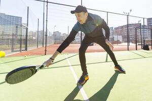 paddle tennis coach teaching on a residential paddle court, front view photo