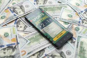 Sports betting website in a mobile phone screen, money photo