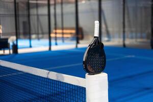 Paddle tennis. Paddel racket and ball in front of an outdoor court photo