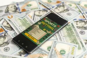 dollars and euros, smartphone with sports bet application photo