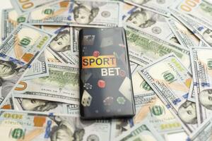 Smartphone with gambling mobile application with money close-up. Sport and betting concept photo