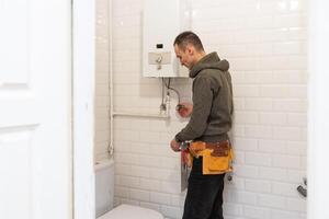 Plumber repairing a toilet cistern photo