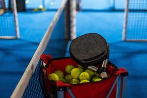 paleta tenis raquetas, pelotas y cesta en Corte todavía vida foto