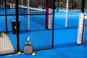 Paddle tennis racket, ball and net on the court photo